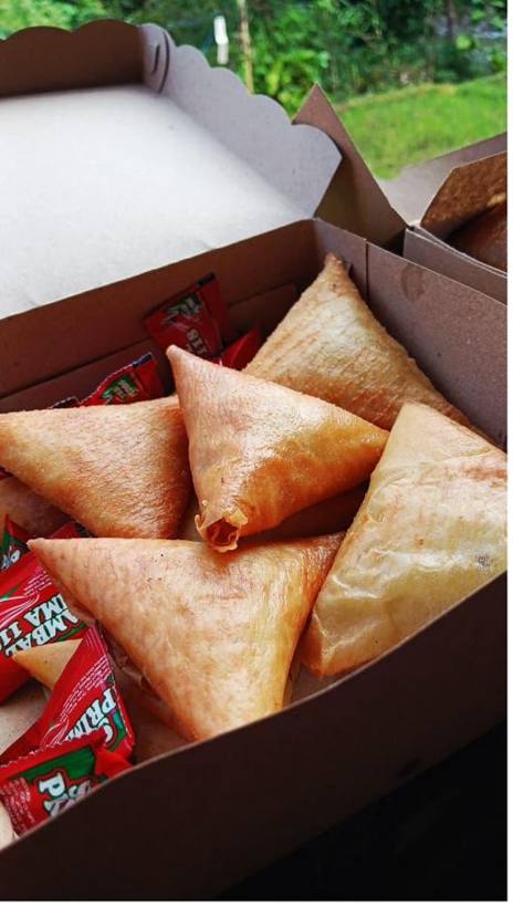 Lumpia segitiga dikemas box kertas, lengkap dengan sambal sachet.